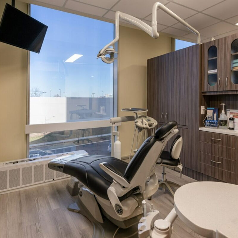 dental exam room with chair, cabinets and equipment